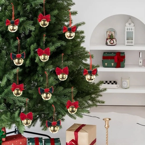 Christmas tree ornaments featuring gold bells with red velvet bows for holiday decoration