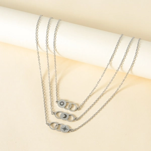 Close-up of three silver necklaces featuring laser-engraved sun, moon, and star pendants