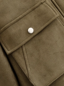 Vue détaillée d'une veste en daim vert olive avec boutons-pression en métal argenté