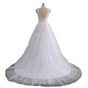 Detailed back view of a lace bridal gown featuring an open back and long tulle train