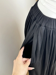 Detail of wide elastic waistband and practical side pocket on black pleated skirt pants