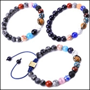 Detail of 8mm volcanic stone and tiger eye bead bracelets with tree of life charm