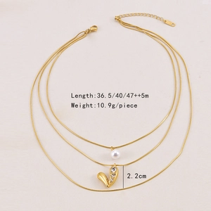 Detail view of gold layered necklace with pearl charms and rhinestone heart pendant