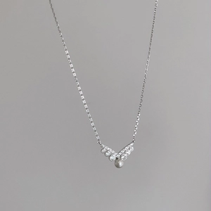 Detailed view of S925 silver V-shaped pendant with cubic zirconia and a white pearl