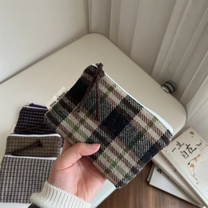 Close-up of thick plaid wool coin purse featuring a zipper and Simple Wish label