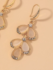 Detail of elegant leaf gold earrings with cat eye stone and sparkling crystals