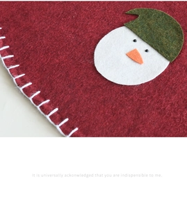 Close-up of red wool felt Christmas tree skirt with snowman embroidery and stitched edge