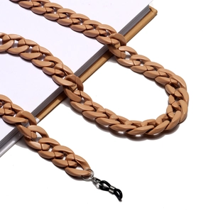 Chunky khaki acrylic eyeglasses chain with rubber loops displayed on a book