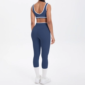 Rückenansicht von dunkelblauem Yoga-Set mit weißem Kontrastbesatz und gekreuzten Trägern
