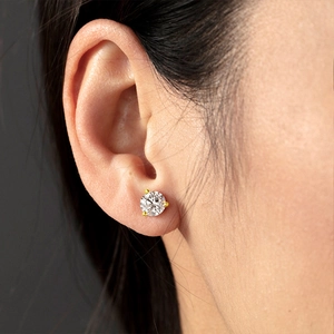 Gros plan d'un clou d'oreille en zircon rond à trois griffes avec placage en or 18 carats