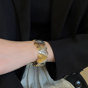 Detail of two-tone heart link bracelet with Laugh, Live, Love engraved inscriptions