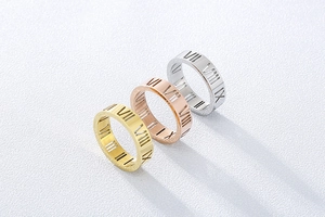 Three-color hollow Roman numeral rings in gold, rose gold and silver on white texture