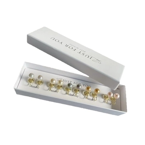 Five pairs of pearl clip-on earrings in a white gift box with weekday labels