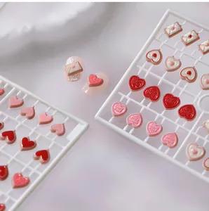 Macro view of 3D resin heart and envelope nail charms with embossed Happy V-Day text