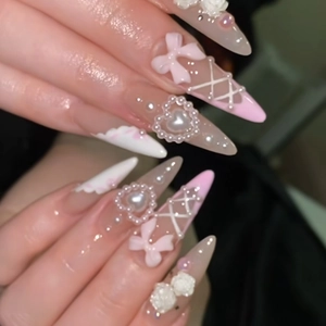 Long stiletto press-on nails with pink bows, white camellia flowers and heart pearls