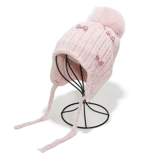 Detailed knit texture and satin bows on a pink winter trapper hat for girls