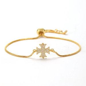 Detailed view of gold cross bracelet with cubic zirconia inlay and adjustable box chain