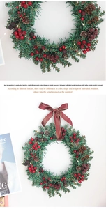 Detail of Christmas wreath with pine needles, red berries, cones, and a velvet bow