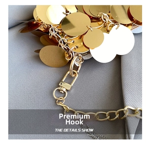 Macro view of a gold sequin bag detailing a high-quality metal lobster clasp and chain