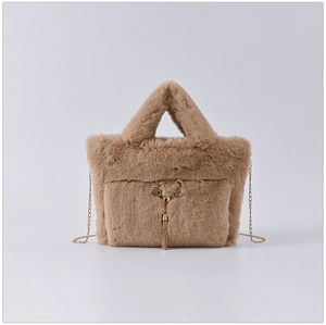 Detail of warm brown faux fur handbag with golden deer head buckle and tassel chain