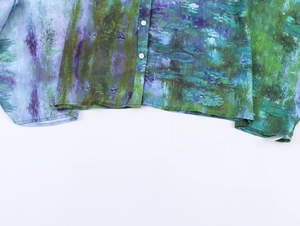 Detail einer lockeren Chiffonbluse mit kunstvollem Ölgemälde-Blumendruck und Knöpfen
