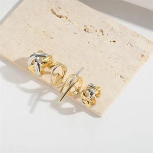 Detailed set of four abstract gold and silver rings with woven and spiral textures