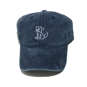 Detail of navy blue washed baseball cap featuring white puppy embroidery and curved brim