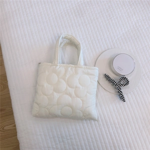 Dettaglio della borsa tote trapuntata bianca con ricamo floreale 3D e morbida texture