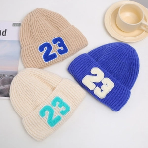 Detail shot of knitted beanies with 23 embroidery, showing fabric texture and color variety