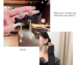 Close-up of elegant black bow earrings with diamond tassel and water drop pearl charms