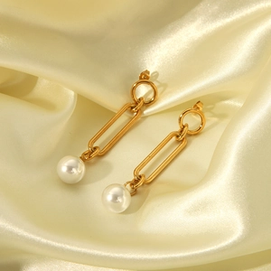 Elegant gold titanium steel long drop earrings with white pearls on yellow silk fabric