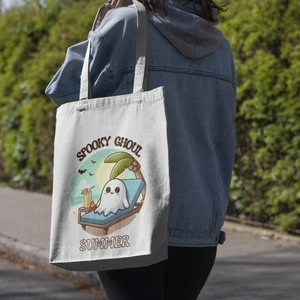 Detail of canvas tote bag with Spooky Ghoul Summer print on woman's shoulder outdoors
