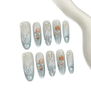 Ocean themed press-on nails with blue cat-eye gradient, shell and 3D fishtail designs
