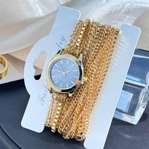 Detail of a vintage-style wrap gold bracelet watch with a black dial on fashion card