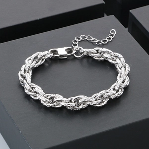 Bracelet chaîne torsadée en acier inoxydable argenté sur un écrin à bijoux noir minimaliste