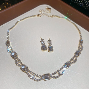 Macro shot of gold square crystal necklace and earrings set with starburst shimmer