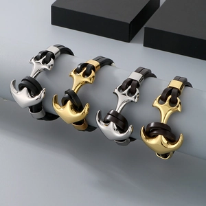 Detail showing four nautical anchor bracelets in gold and silver with braided leather