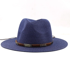 Détail d'un chapeau de paille bleu foncé avec boucle vintage et bande en cuir brun