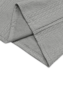 Detailed macro view of gray knitted fabric with geometric jacquard pattern and stitching