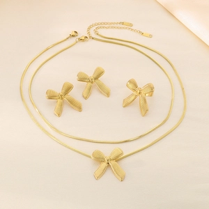 Elegant 18K gold plated snake chain necklace and bow jewelry set on silk background