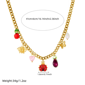 Gold chain necklace with colorful ladybug bee and cherry charms on white background