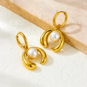 Elegant gold-plated horseshoe earrings with white pearls for women on textured background