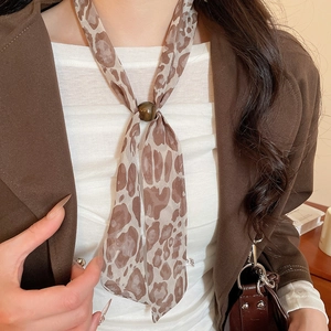 Detail showing chic leopard print skinny scarf with brown bead ring on model's neck