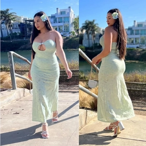 Pale green strapless maxi dress with cutout details and lace pattern shown in outdoor view