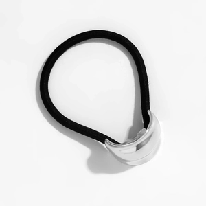 Macro detail of elastic hair band featuring a polished silver metallic crescent ornament