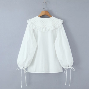White long sleeve shirt with large lace collar and bow cuffs on neutral background