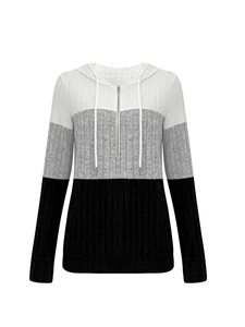 Detail of color-block knit hoodie with half-zip and ribbed texture in white, grey, and black