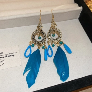 Boho-Ohrringe in Gold mit leuchtend blauen Federn und dekorativen Perlen