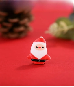Macro shot of a cute resin Santa Claus DIY accessory with festive red background