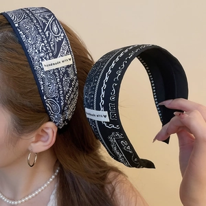 Détail du serre-tête en tissu paisley avec étiquette faite main et texture bleu marine